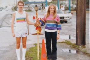 man and woman holding olympic torch