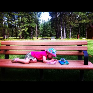 toddler coloring on park bench